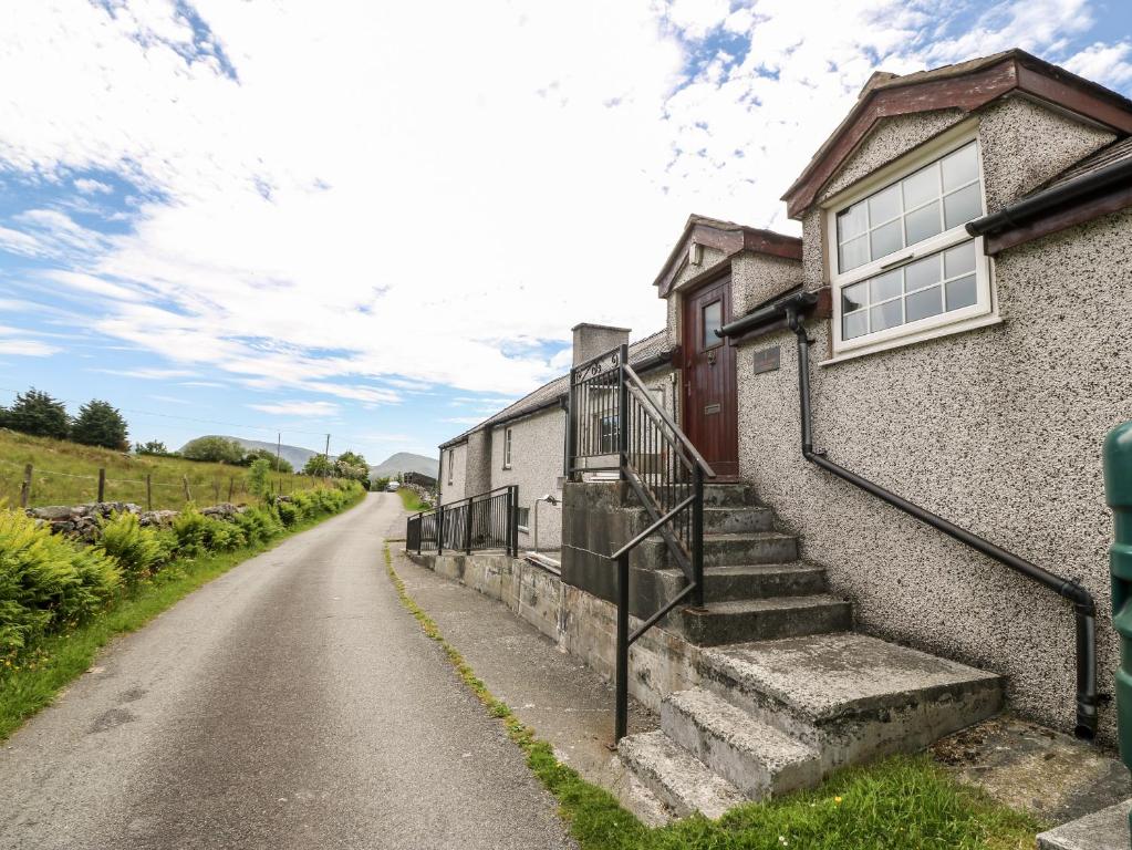 a house with stairs on the side of a road at Glan y Gors in Dinorwic