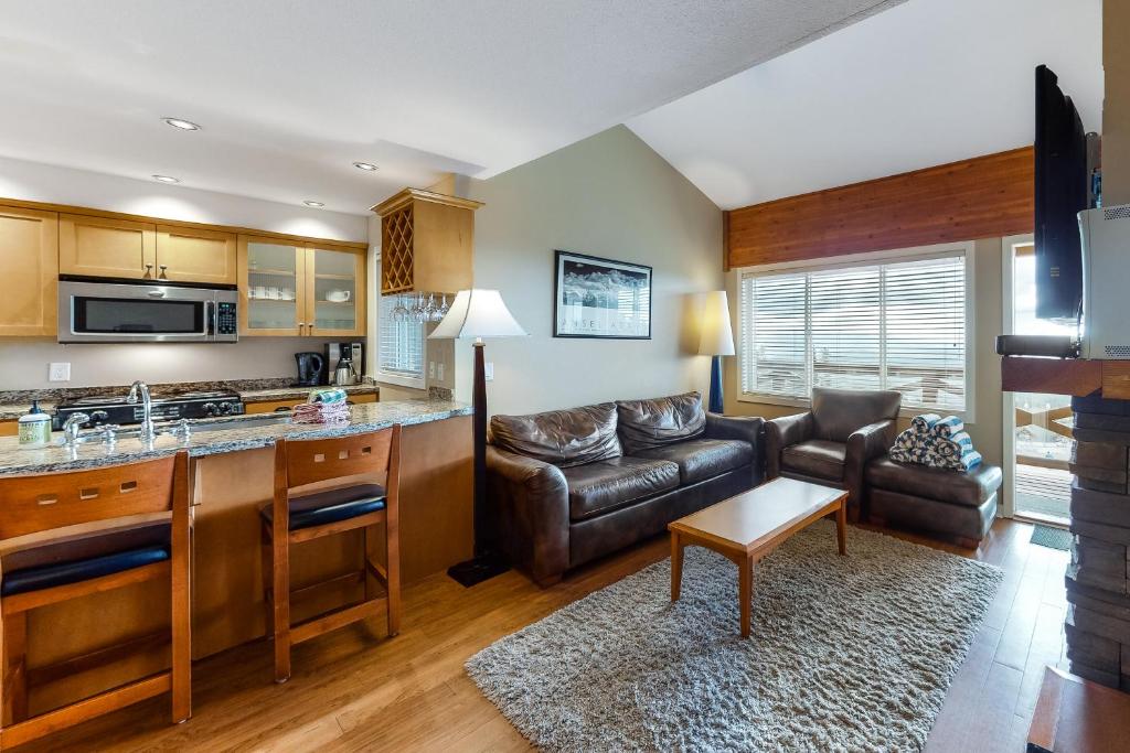 a kitchen and living room with a couch and a table at Trappers Crossing 22 in Big White