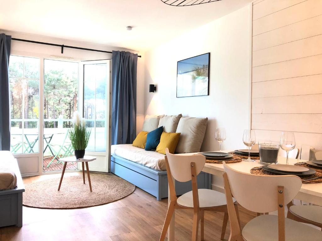 un salon avec un canapé et une table dans l'établissement Ravissant Appartement au Domaine du Golf, à Lacanau