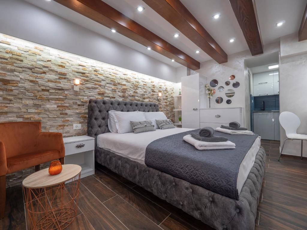 a bedroom with a bed and a brick wall at Luxury Boutique Studio in Budva