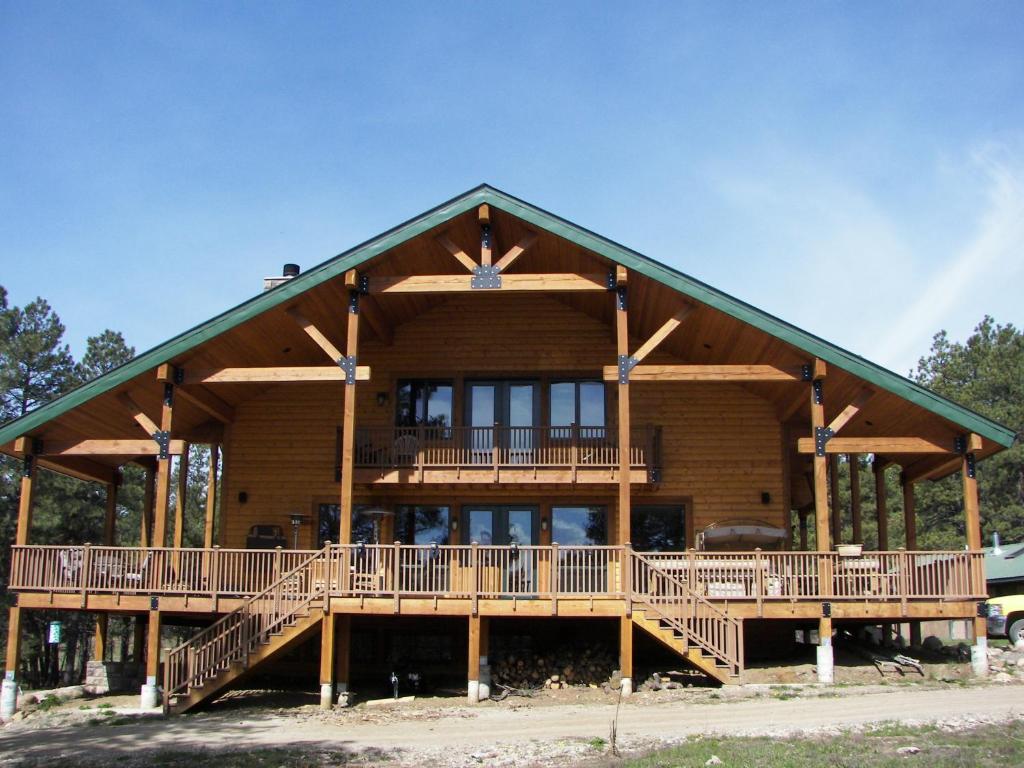 une grande maison en bois avec une grande terrasse dans l'établissement Elktrace Bed and Breakfast, à Pagosa Springs