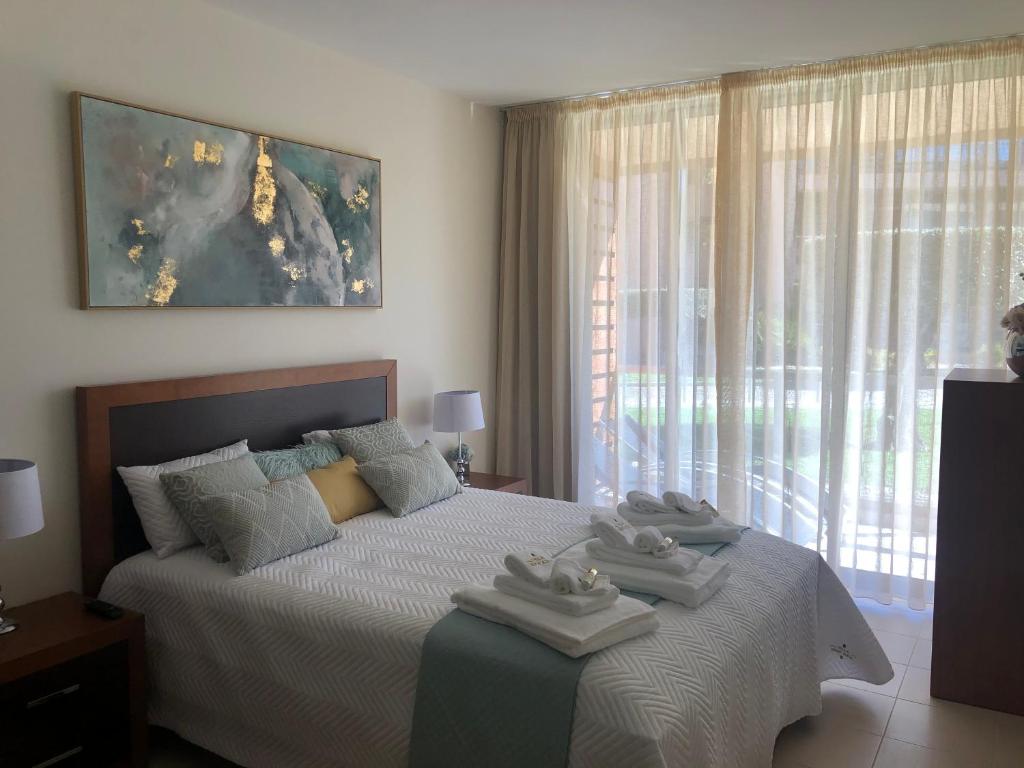 a bedroom with a bed with two towels on it at Vila das Lagoas in Albufeira