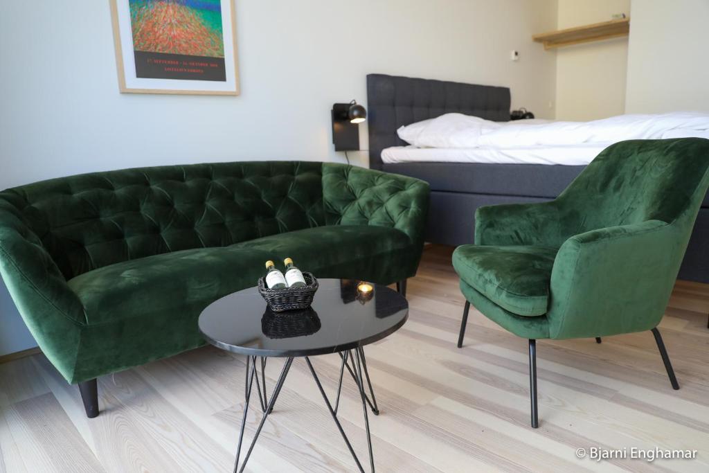 a living room with a couch and two chairs and a table at Mølin Guesthouse in Skálavík