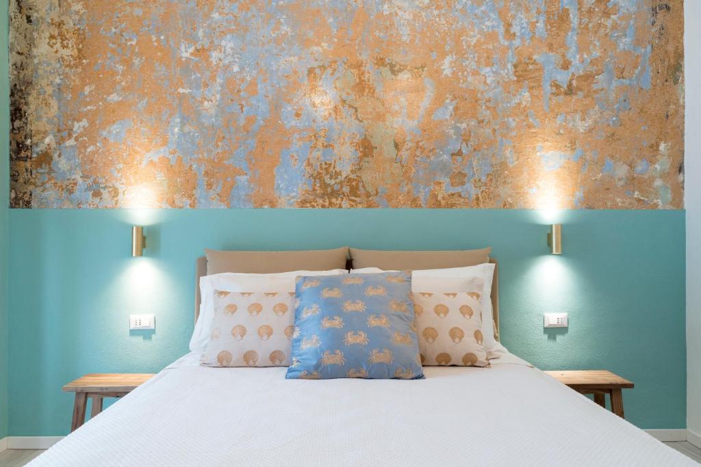 um quarto com uma cama com um quadro na parede em VALÚ em Carloforte