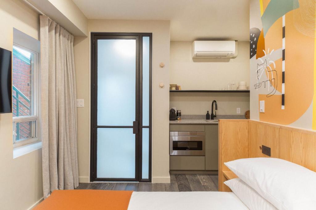 a small room with a bed and a kitchen at Ode in Toronto