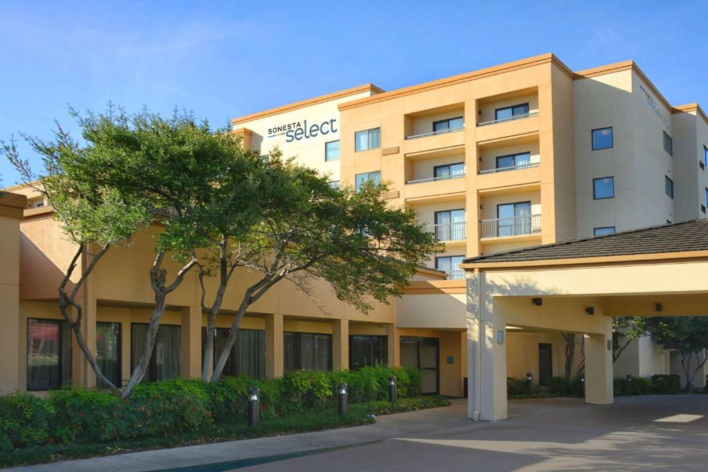 a hotel building with trees in front of it at Sonesta Select Dallas Central Expressway in Dallas