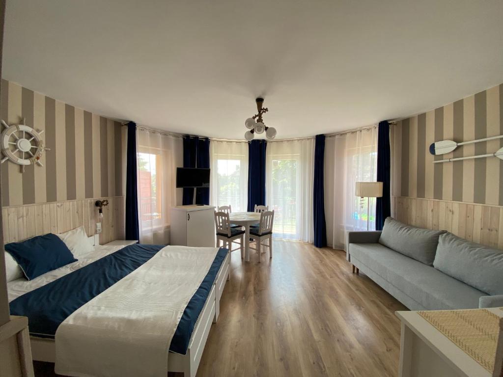 1 dormitorio con cama, sofá y mesa en Toskania Pokoje Goscinne en Karwia