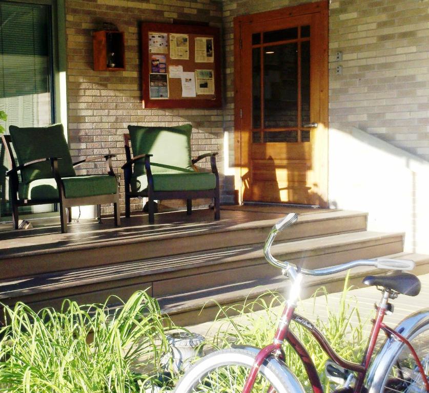 a porch with chairs and a bike parked on it at Summers Inn Ludington - Adults Only in Ludington