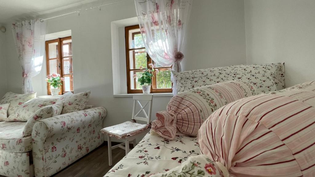 a bedroom with a bed and a couch and windows at Apartmány Na Návsi 19 u Hluboké in Hrdějovice