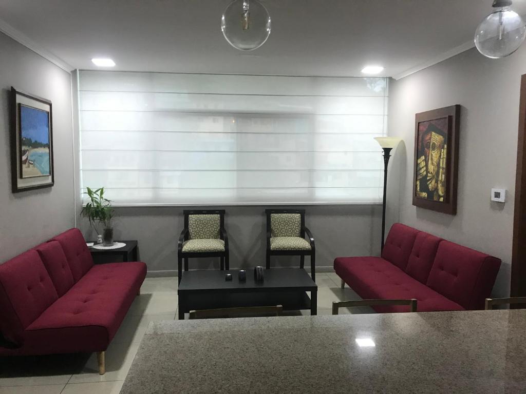 una sala de espera con sofás y sillas rojos en Apartamento completo Edificio Riverfront 1 Puerto Santa Ana, en Guayaquil