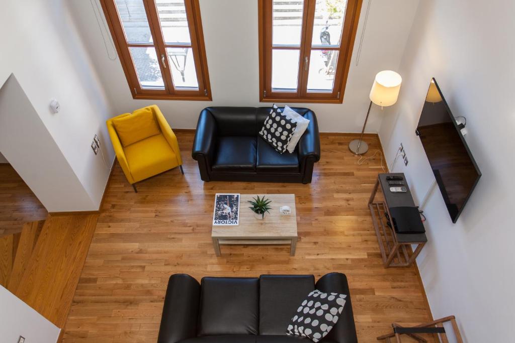 an overhead view of a living room with a couch and a yellow chair at Agora Suites in Chania