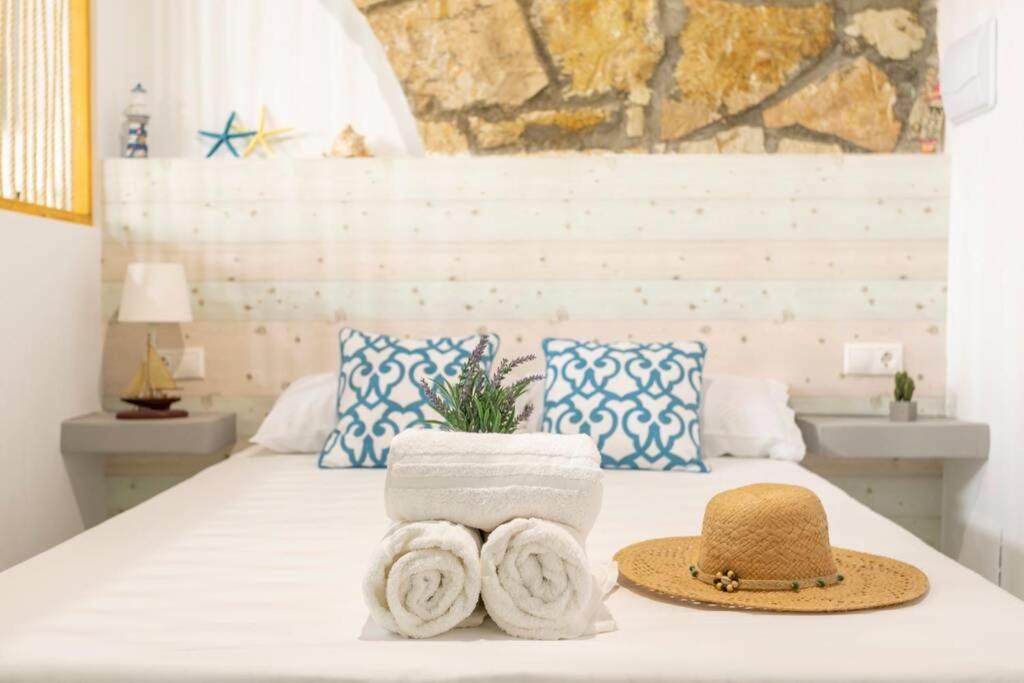 ein Bett mit Handtüchern und einem Hut darauf in der Unterkunft apartamento loft a 50 metros de la playa y paseo maritimo in El Campello