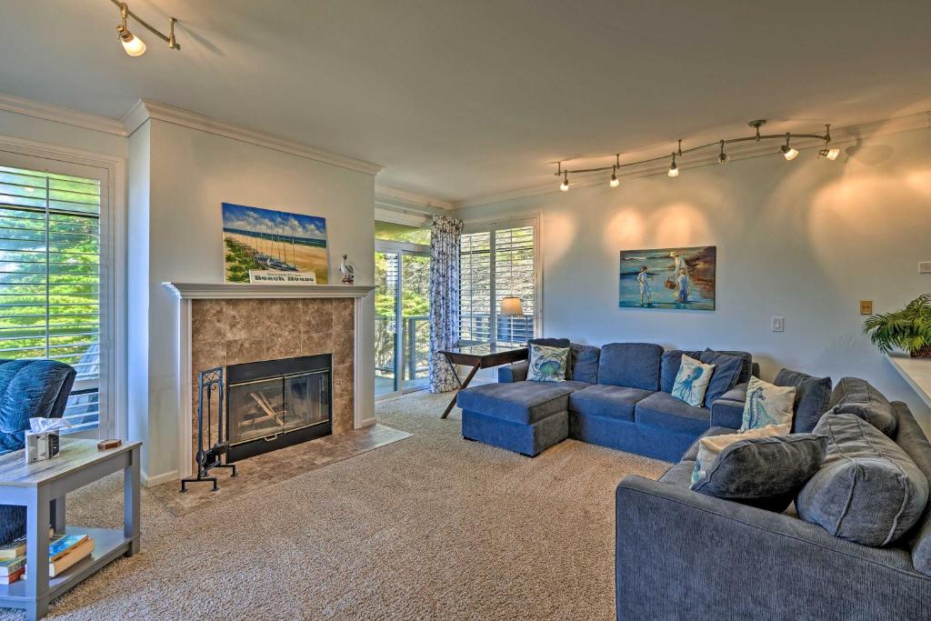 a living room with a blue couch and a fireplace at Beachfront Pajaro Dunes Condo w/ Bay Views! in Watsonville
