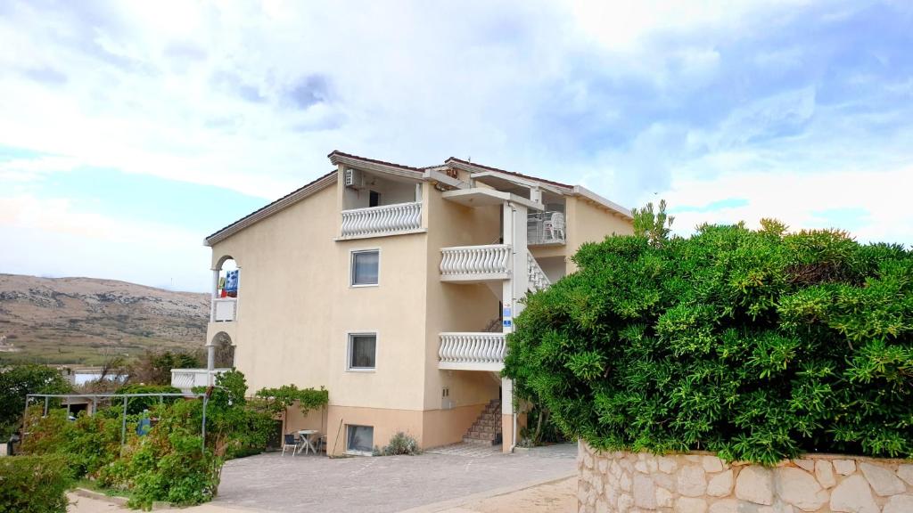 a building with balconies on the side of it at Apartments Toro in Pag