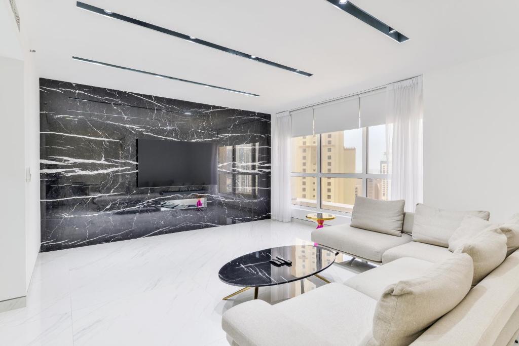 a living room with a white couch and a black wall at Waterfront Luxury 3BR with maids room in JBR, Dubai in Dubai