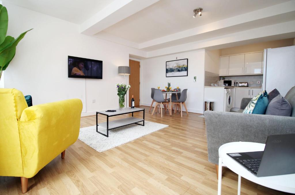 a living room with a yellow couch and a table at St Thomas Loft Views by Stay South Wales in Swansea
