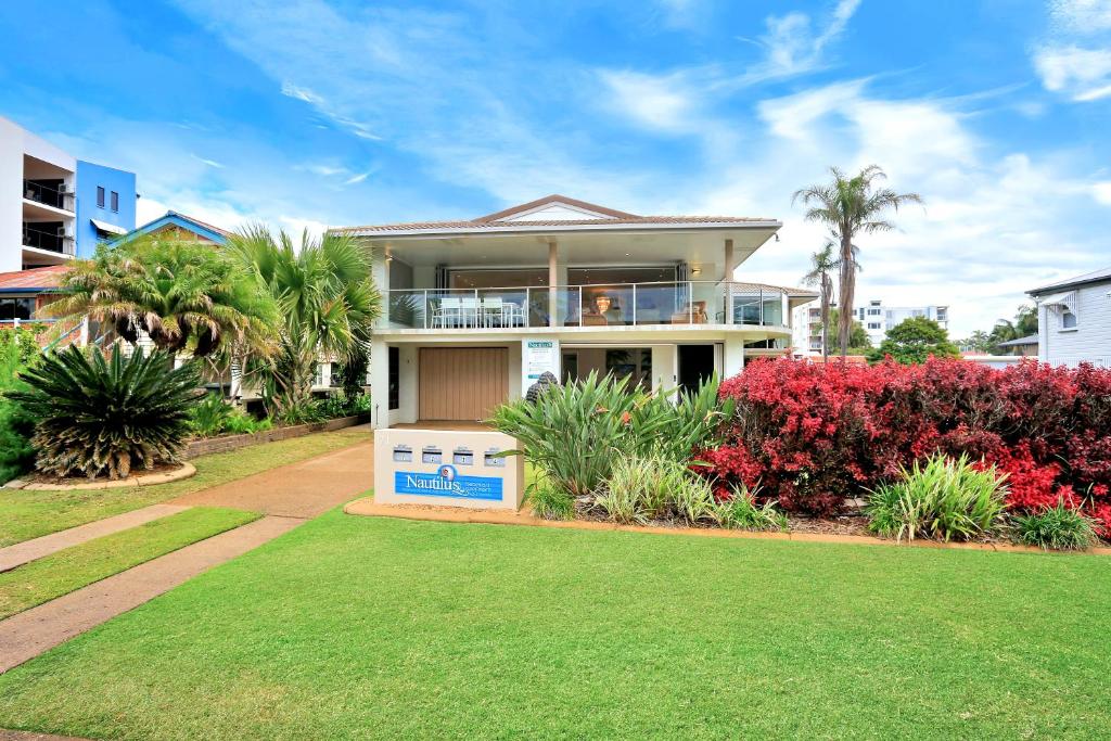 a house with a lawn in front of it at Nautilus Beachside Apartments in Bargara