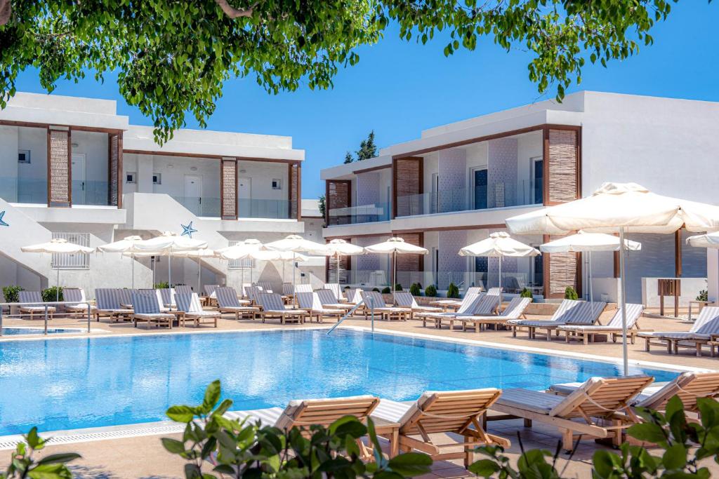 una piscina de hotel con sillas y sombrillas en Aelius Hotel and Spa, en Gouves
