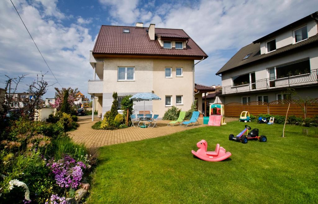 een tuin met twee kinderen die in het gras spelen bij Willa Oskar in Władysławowo