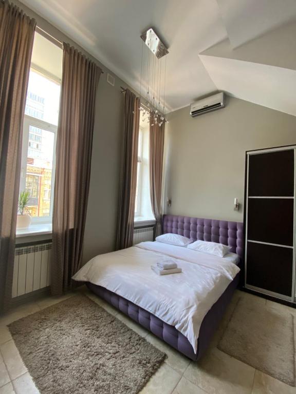 a bedroom with a purple bed and a window at Opera Apart Hotel in Kyiv