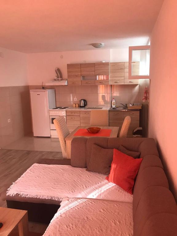 a living room with a couch and a table and a kitchen at Stan Vukovic in Bar