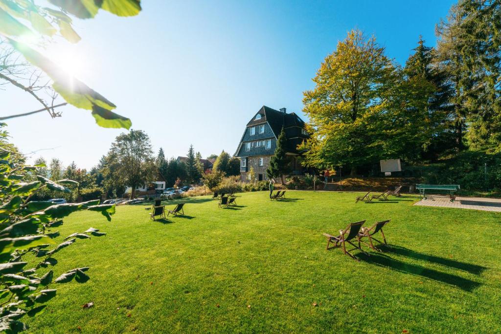 ein Park mit Bänken im Gras mit einem Gebäude in der Unterkunft THE HEARTS HOTEL - dein Boutique- und Event-Resort in Braunlage