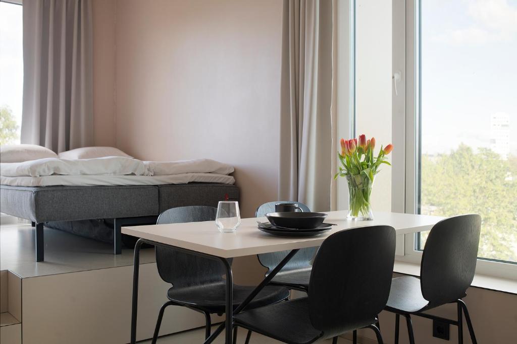 Hugo Apartment Hotel في تارتو: غرفة مع طاولة وكراسي وسرير