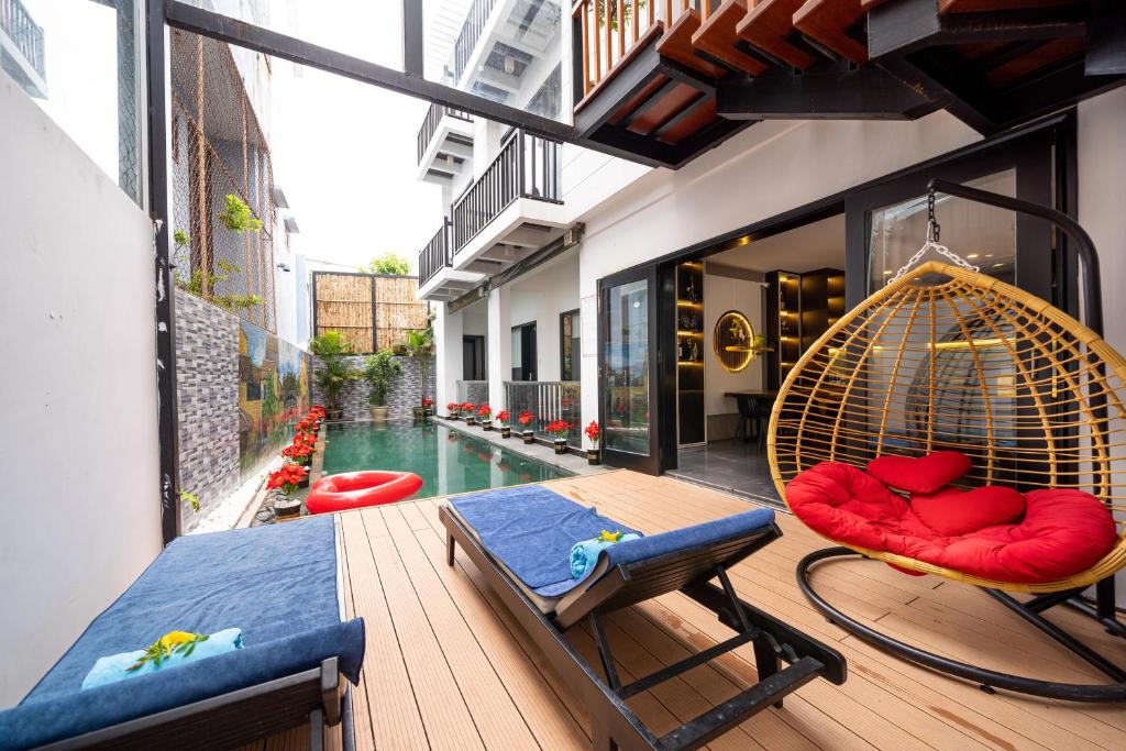 a balcony with a swing and a swimming pool at Ki No Pool Villa Hoi An in Hoi An