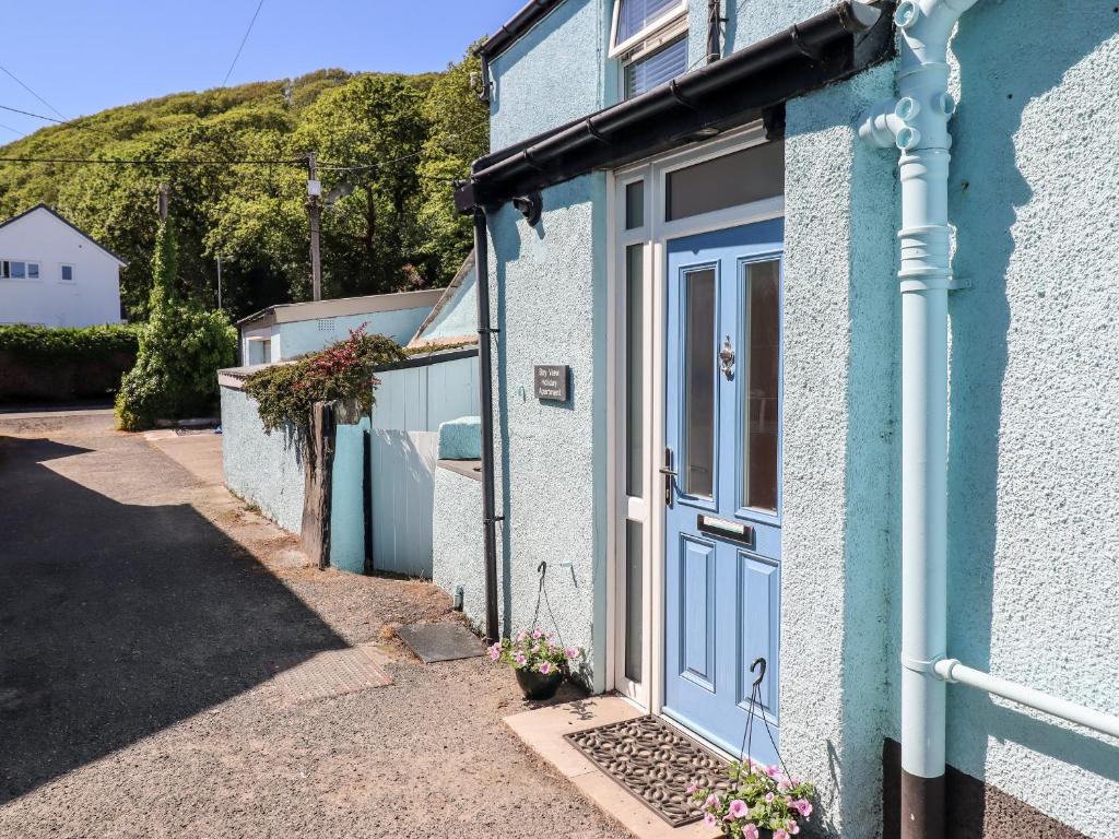 a blue house with a blue door on a street at Bay View Apartment in Porthmadog