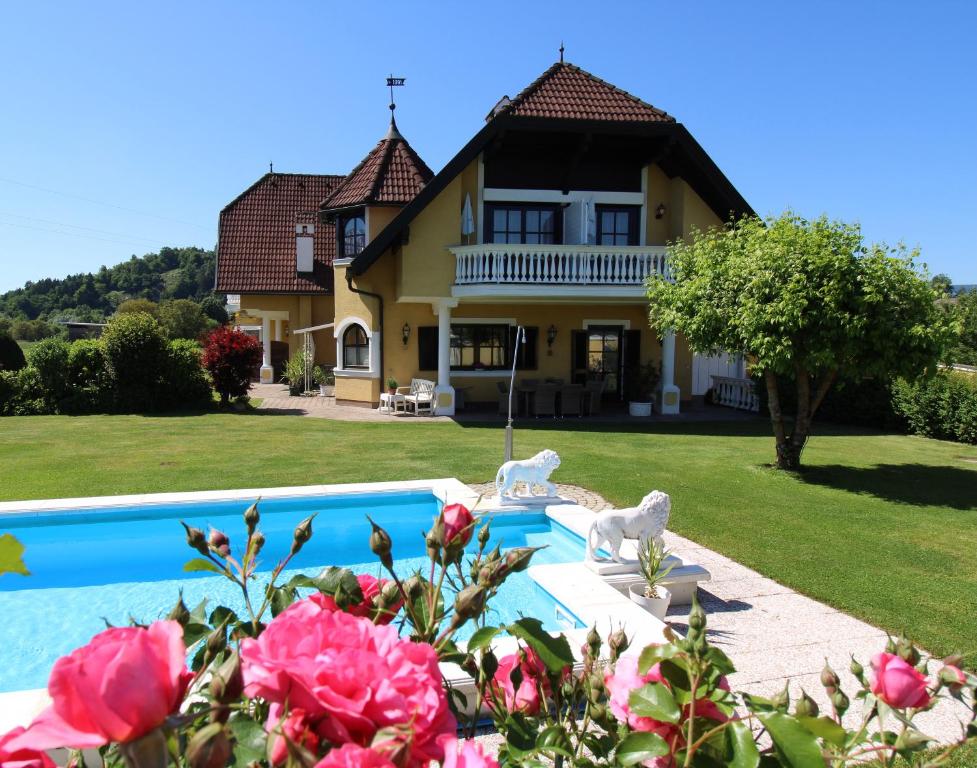 eine Villa mit einem Pool vor einem Haus in der Unterkunft Appartements Panorama Schlössl in Velden am Wörthersee