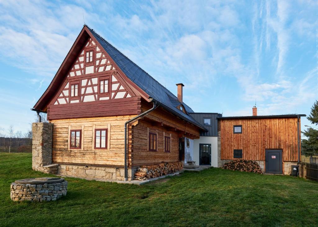 a large wooden house with a gambrel roof at Roubenka U Babi in Lipná