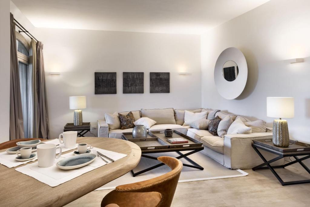 ein Wohnzimmer mit einem Sofa und einem Tisch in der Unterkunft Le Suites Porto Cervo in Porto Cervo