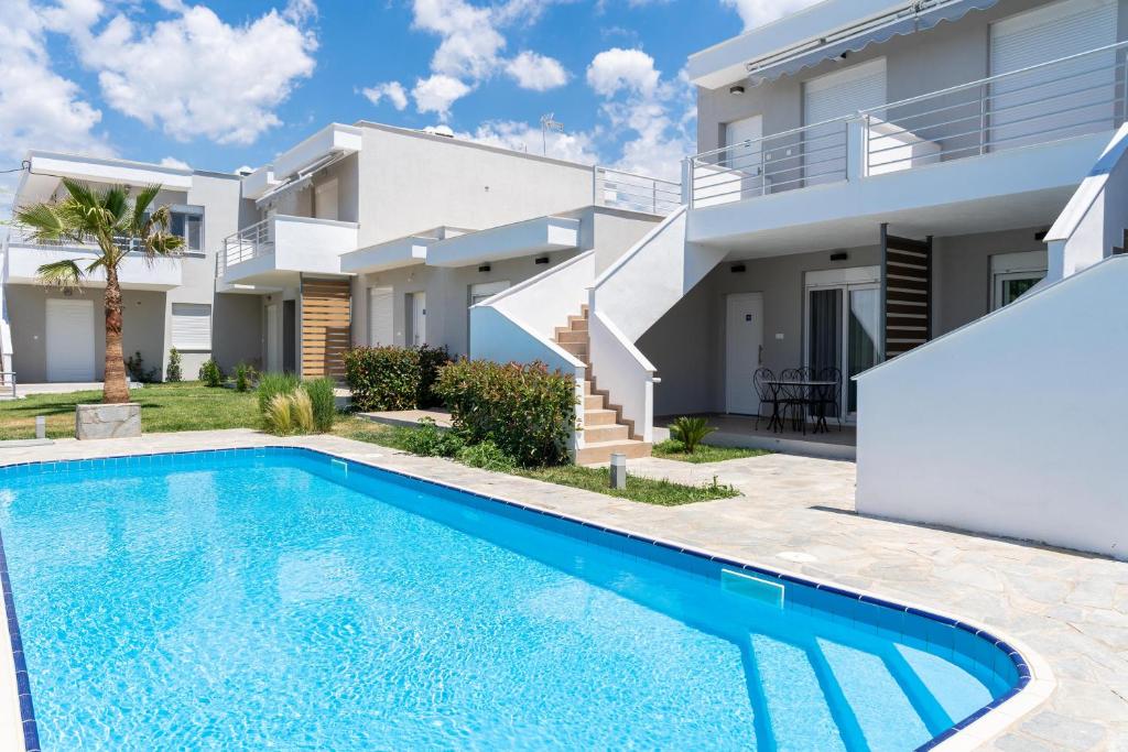 Villa con piscina frente a una casa en Danai & Palm Residential Complexes, en Ofrinion