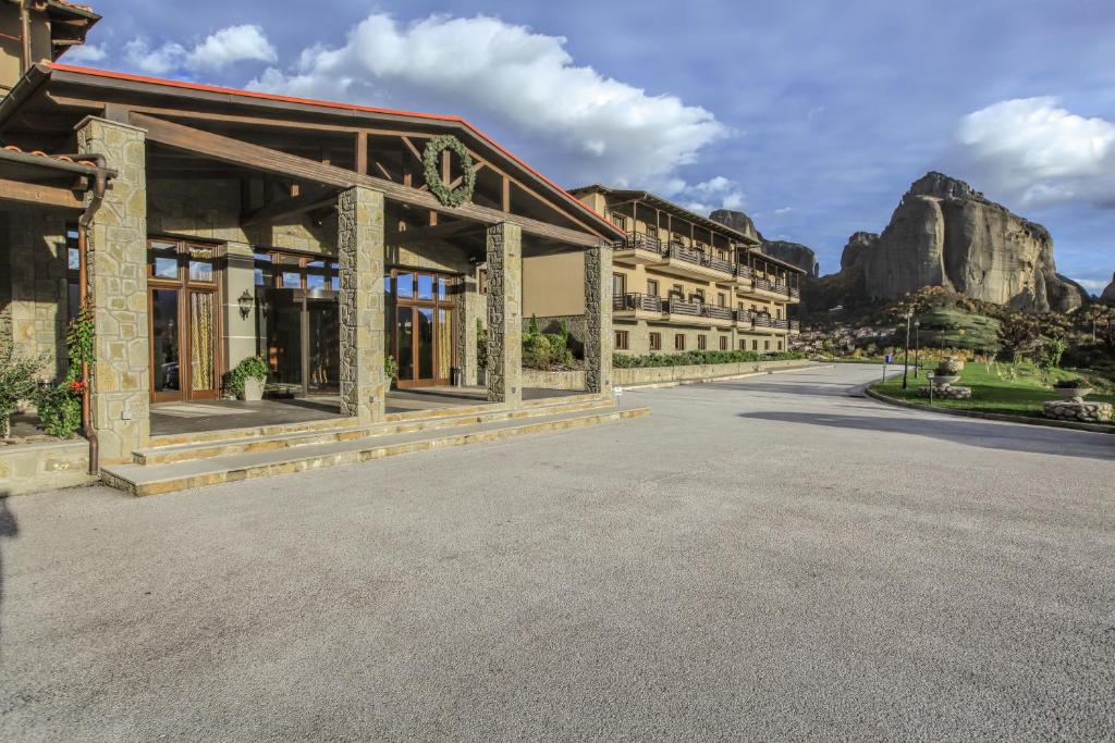 a large building with a mountain in the background at Grand Meteora Hotel in Kalabaka