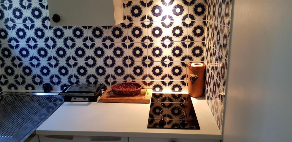 una cocina con azulejos blancos y negros en la pared en Studio avec terrasse 2 personnes, en Le Lavandou
