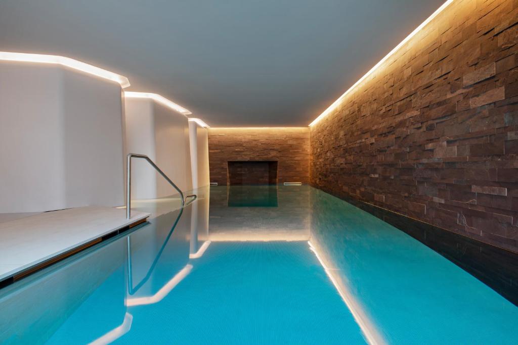 a house with a swimming pool and a brick wall at Hotel Les Haras in Strasbourg