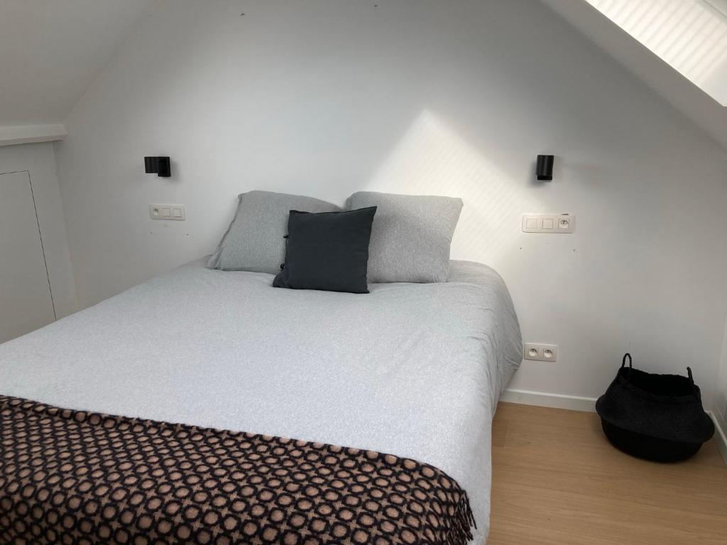 a bed with two pillows on it in a room at Semarane in Knokke-Heist