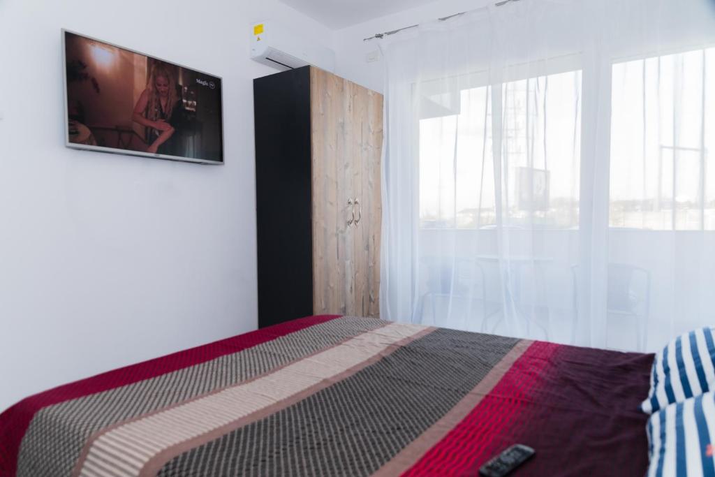 オラデアにあるApartament Westの壁にテレビが付いたベッドのある寝室