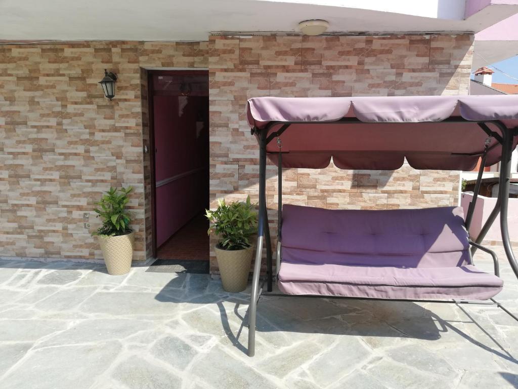 a porch with a purple canopy and two potted plants at Студия Синя приказка in Sozopol