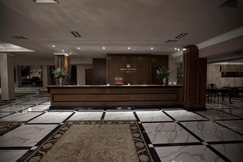 a lobby with a bar in the middle of a building at Grand Meteora Hotel in Kalabaka