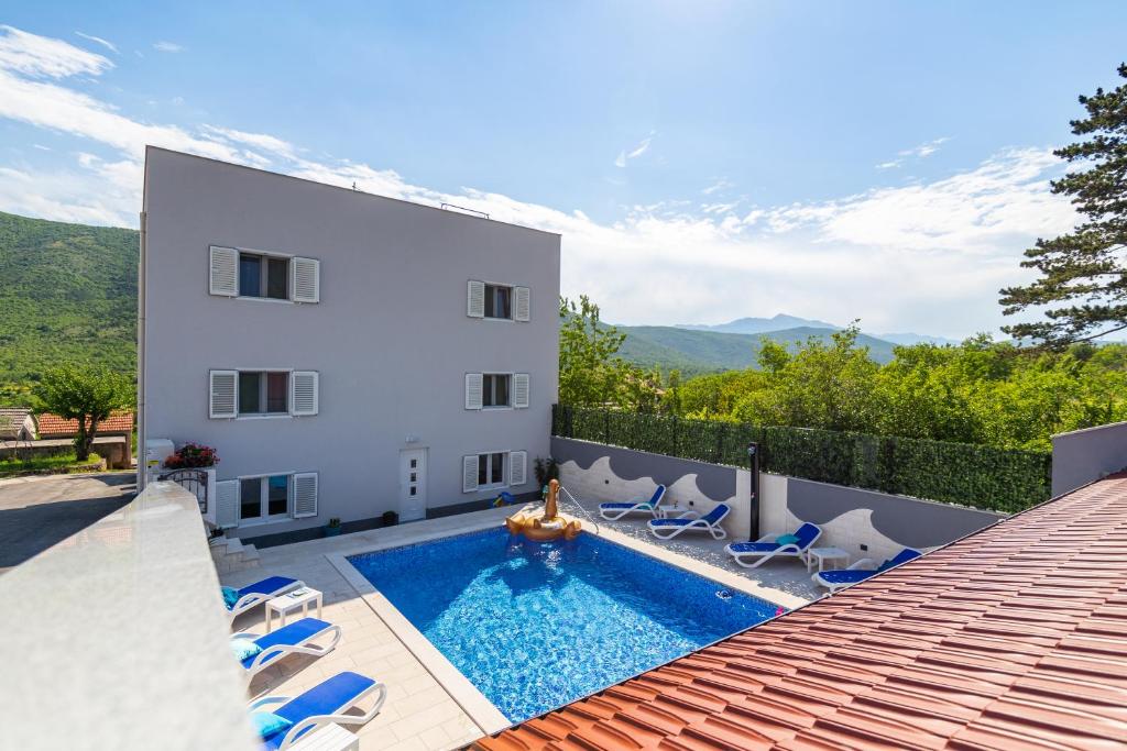 a house with a swimming pool next to a building at VILLA STARS HILL WITH HEATING POOL and JACUZZI - MAKARSKA in Slivno