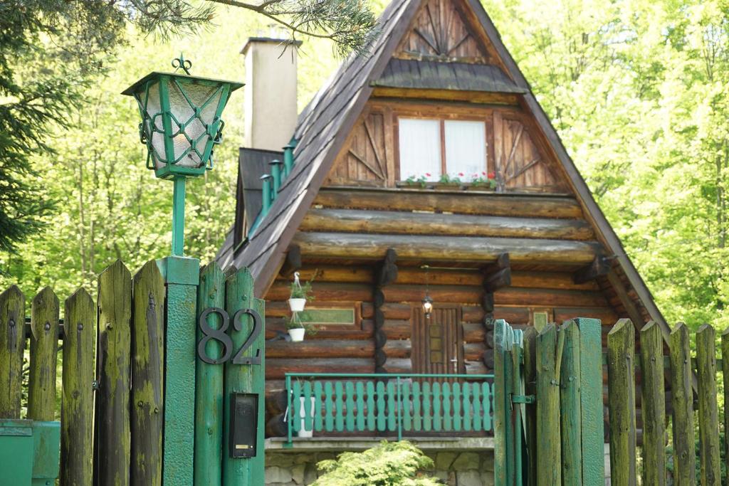 uma cabana de madeira com uma cerca e uma luz de rua em Kosarzówka em Bielsko-Biala