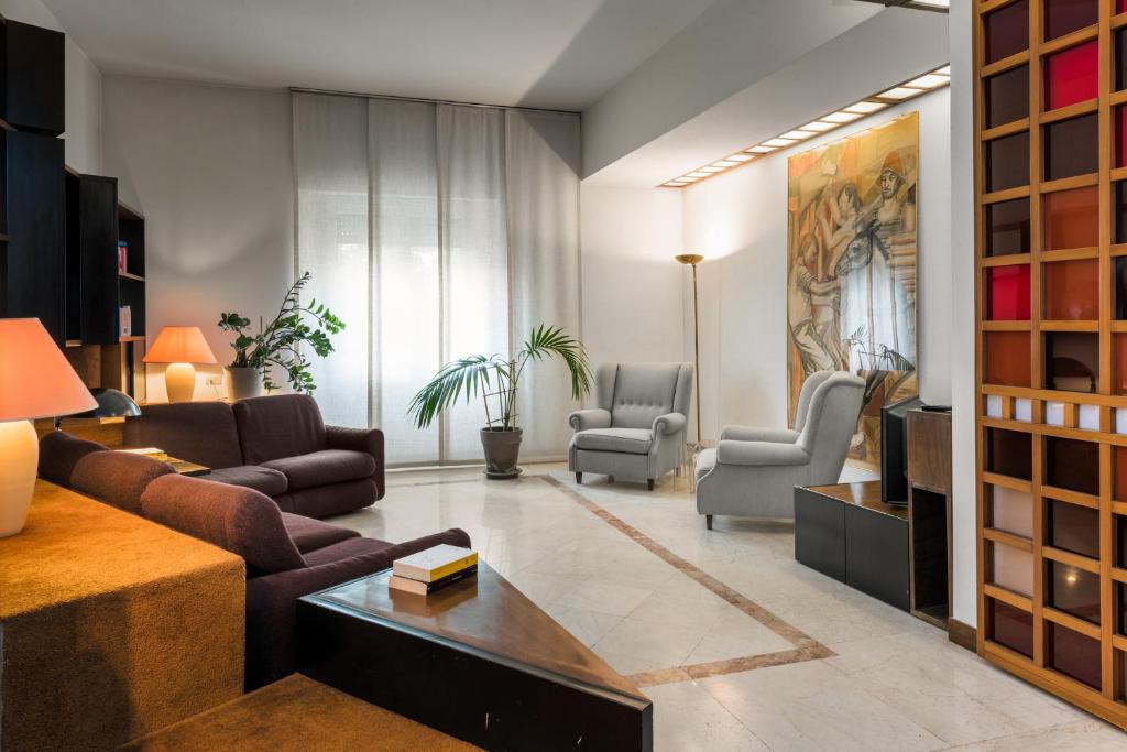 un soggiorno con divano e 2 sedie di Flats4rent Residenza ai Tigli a Verona