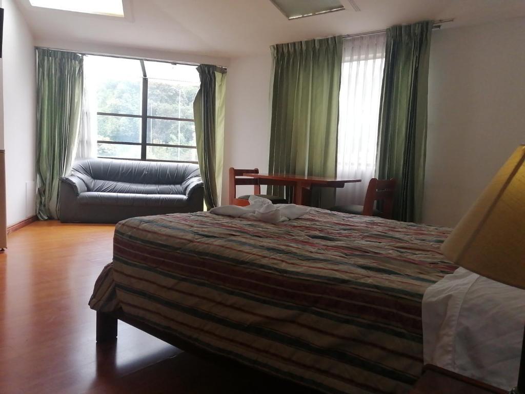 1 dormitorio con cama, sofá y ventana en Room in Guest room - Amazing Junior Suite Close The Airport And Trade Center, en Bogotá