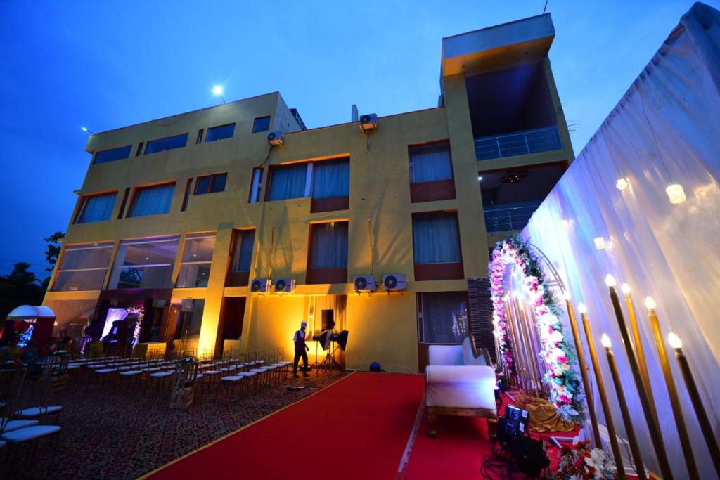 Devanhalli的住宿－Airport Residency，站在一座红地毯建筑前面的人