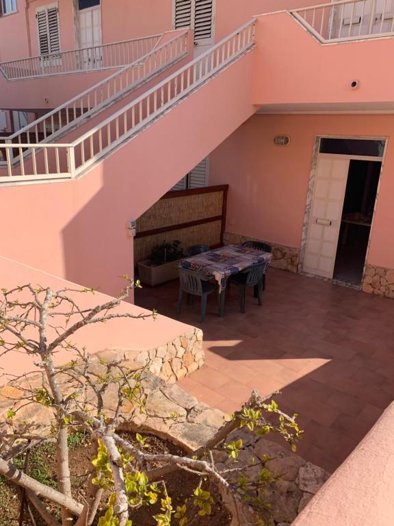un patio de una casa con una mesa y una escalera en Lopadusa trilo 2, en Lampedusa