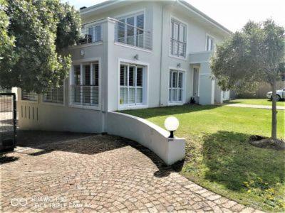 a large white house with a driveway in front of it at Mystic Breeze in Hermanus