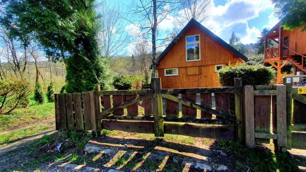 a wooden fence in front of a house at Leśniczówka Święty Spokój Bieszczady in Ropienka