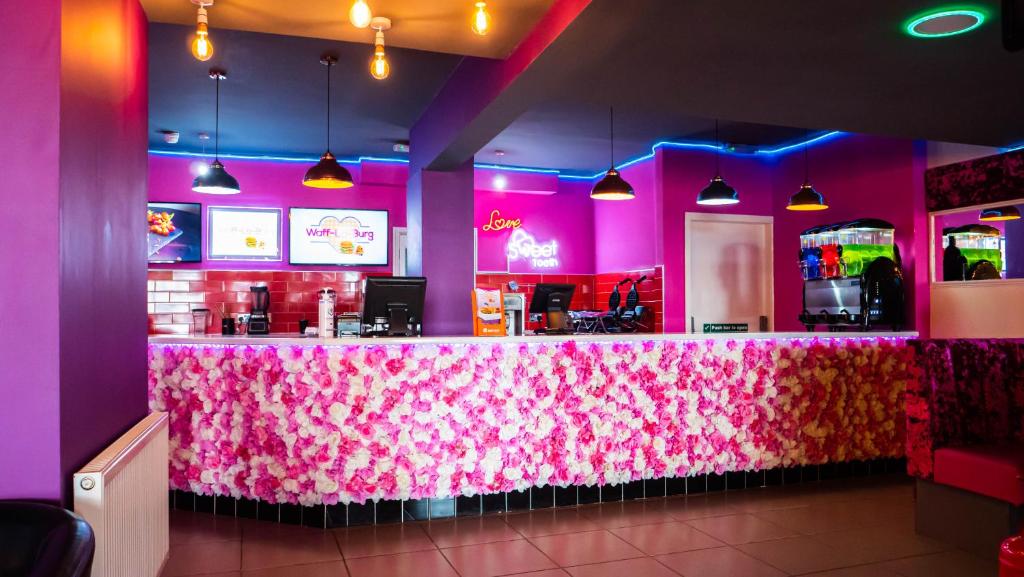 a pink restaurant with a bar with a pink counter at Hello Roomz - Pleasure Beach in Blackpool