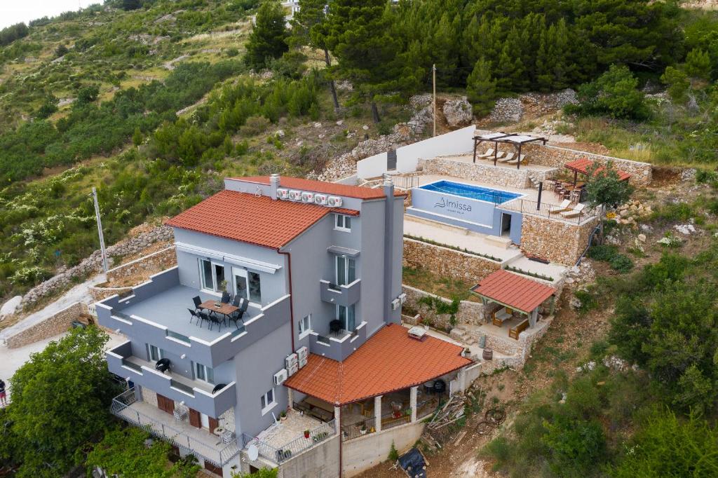eine Luftansicht eines Hauses mit Pool in der Unterkunft Exclusive Villa Almissa with swimming pool and sea view in Lokva Rogoznica